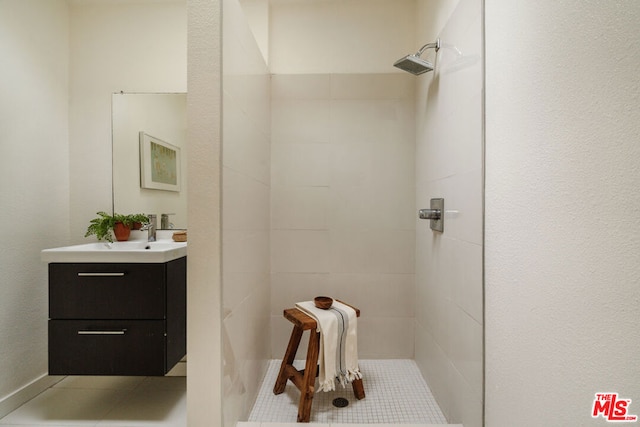 bathroom featuring tile patterned floors, vanity, and a tile shower