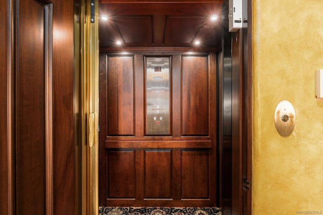 details featuring elevator and wooden walls