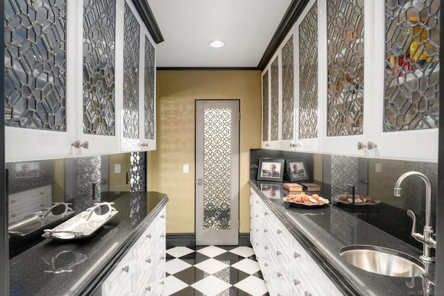 kitchen featuring sink, white cabinetry, and crown molding