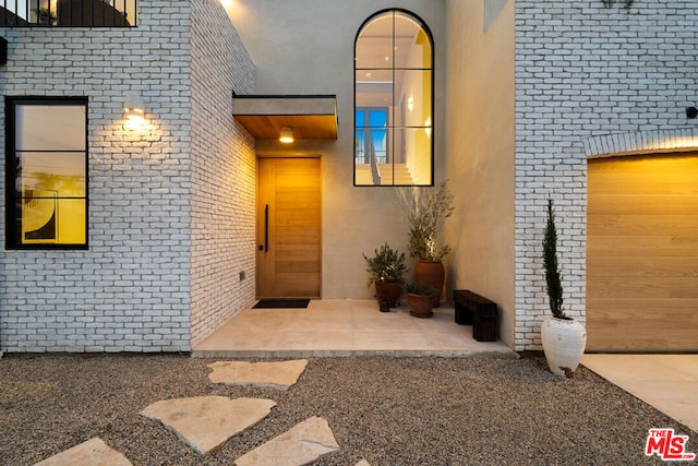 entrance to property with a garage and a patio