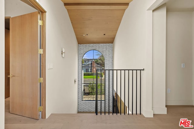 hallway featuring light hardwood / wood-style flooring, vaulted ceiling, and wooden ceiling