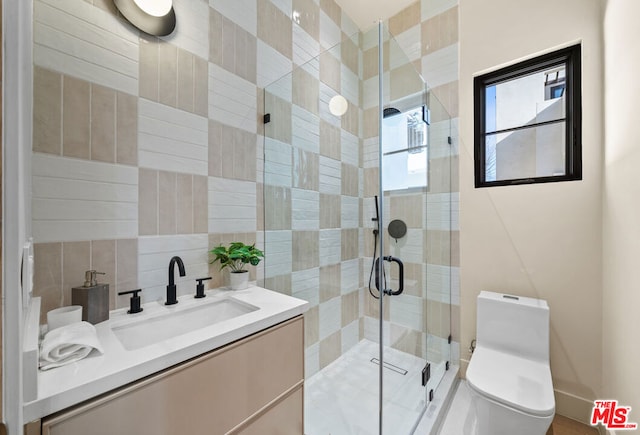 bathroom featuring vanity, toilet, and a shower with door