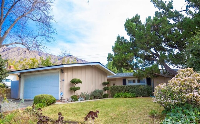 ranch-style house with a garage, a front lawn, and a mountain view