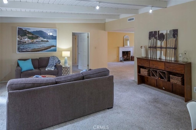 carpeted living room featuring rail lighting, beam ceiling, and wood ceiling