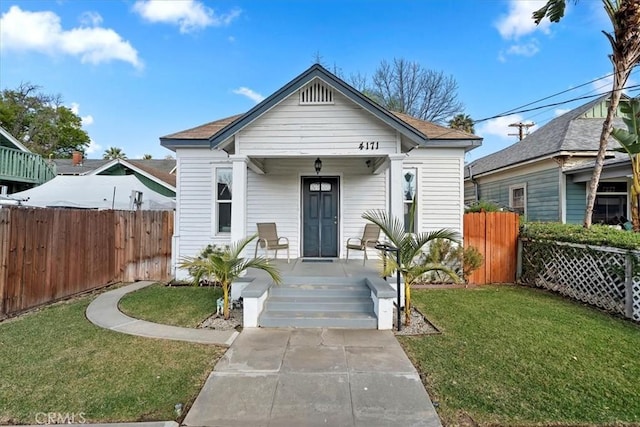 bungalow with a front lawn and covered porch