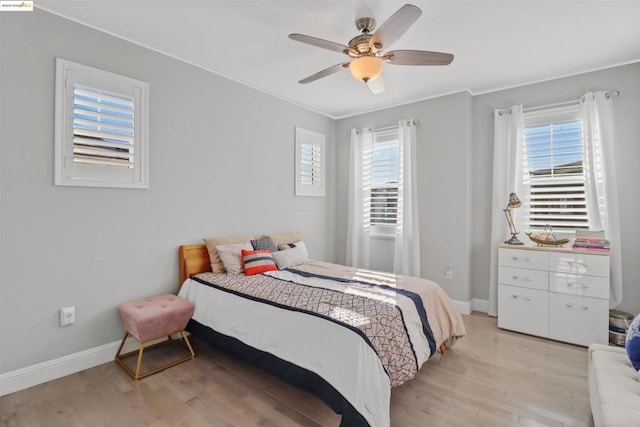 bedroom with ceiling fan, multiple windows, ornamental molding, and light hardwood / wood-style flooring