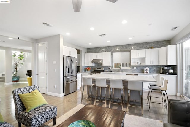 kitchen featuring tasteful backsplash, appliances with stainless steel finishes, a center island, and white cabinets