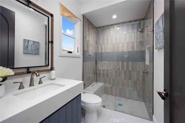 bathroom with walk in shower, vanity, and toilet