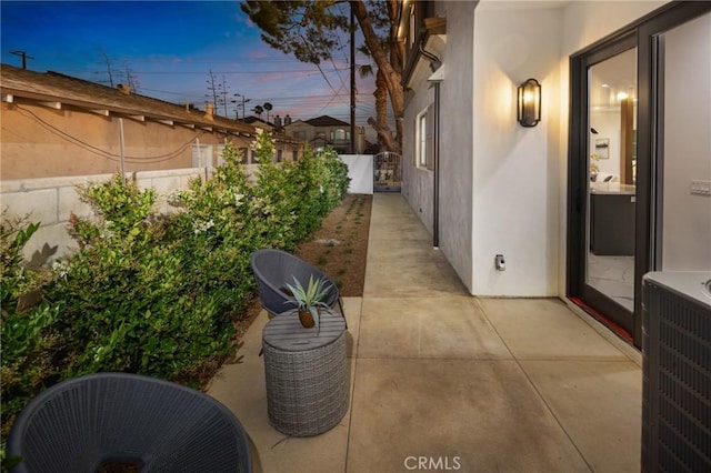 patio terrace at dusk featuring central AC