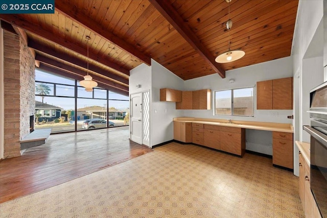 kitchen featuring decorative light fixtures, built in desk, beamed ceiling, high vaulted ceiling, and wooden ceiling