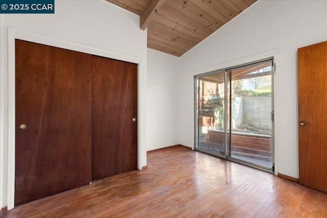 unfurnished bedroom with wood-type flooring, vaulted ceiling with beams, a closet, access to outside, and wooden ceiling