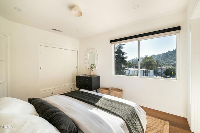 bedroom with wood-type flooring and a closet