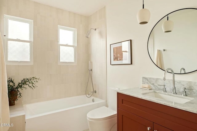 full bathroom with toilet, vanity, and tiled shower / bath