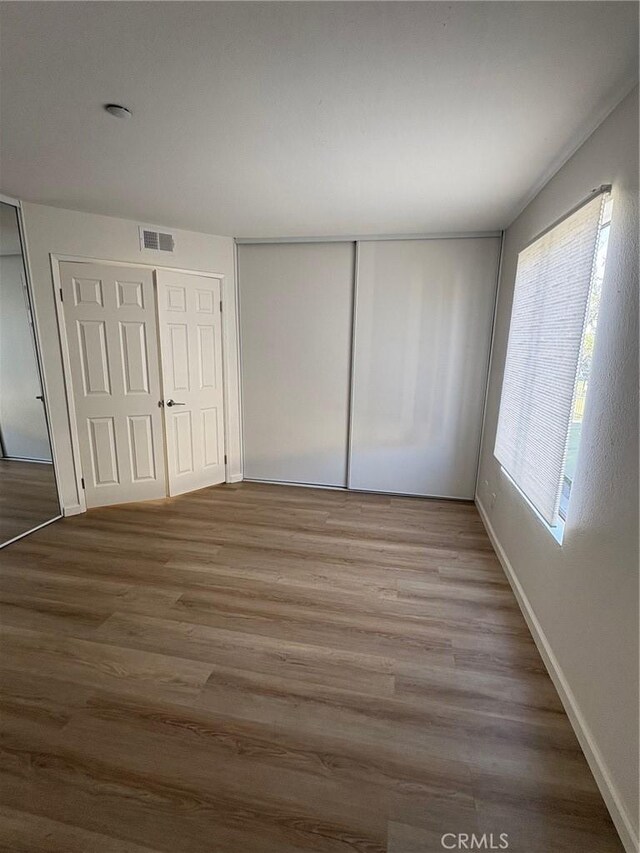 unfurnished bedroom with hardwood / wood-style flooring