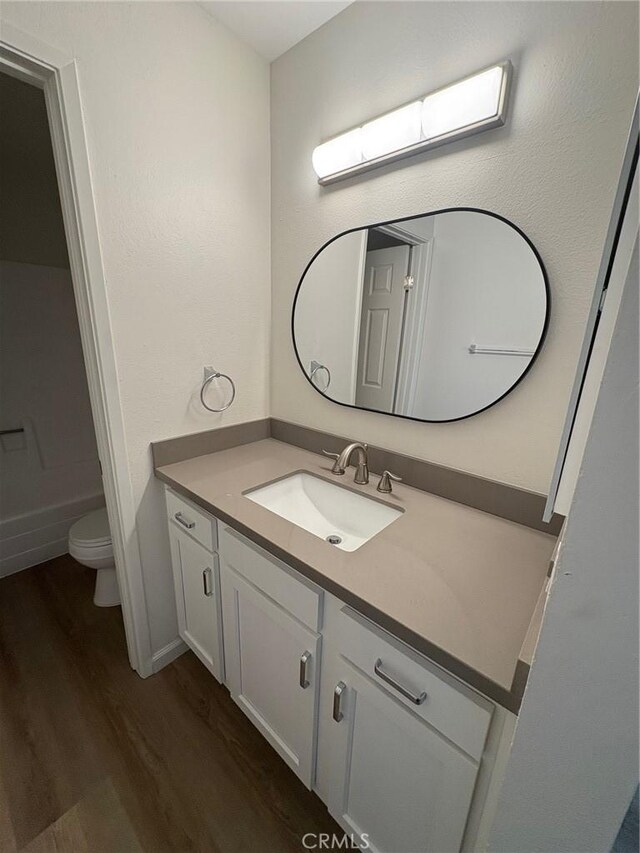 bathroom featuring hardwood / wood-style floors, toilet, and vanity