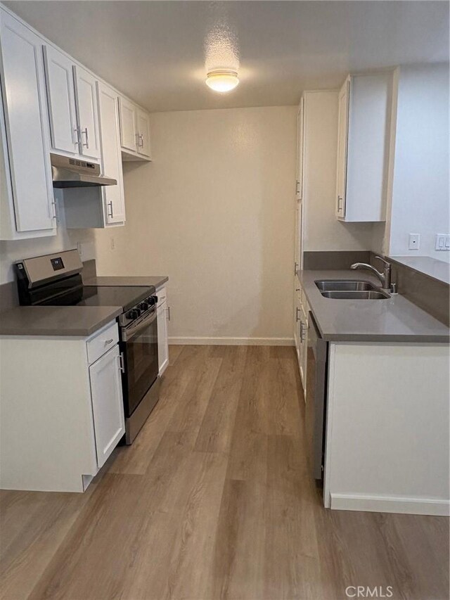 kitchen featuring appliances with stainless steel finishes, a textured ceiling, white cabinetry, sink, and light wood-type flooring