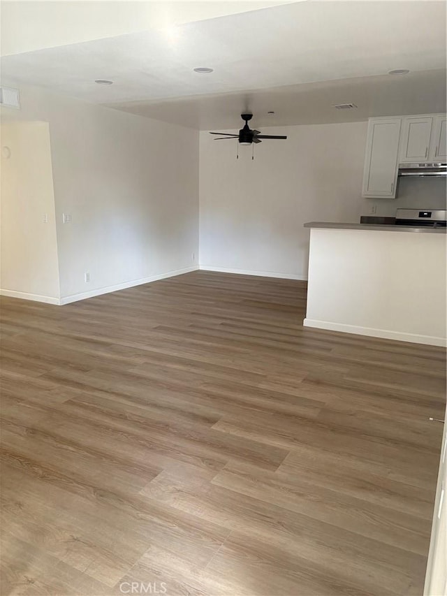 unfurnished living room featuring ceiling fan and light hardwood / wood-style floors