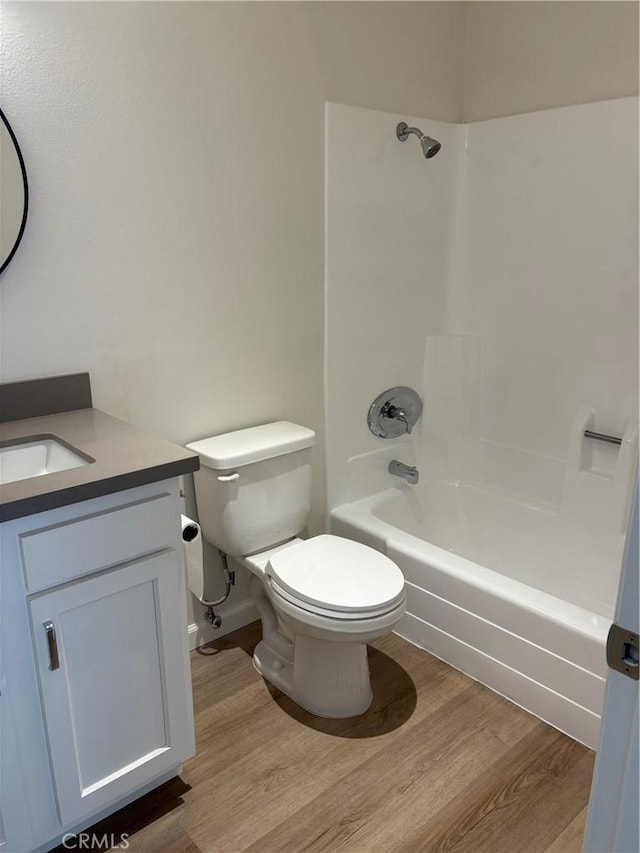 full bathroom featuring vanity, hardwood / wood-style flooring, shower / bath combination, and toilet