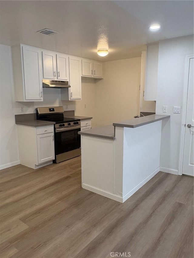 kitchen with kitchen peninsula, white cabinetry, and stainless steel electric range oven