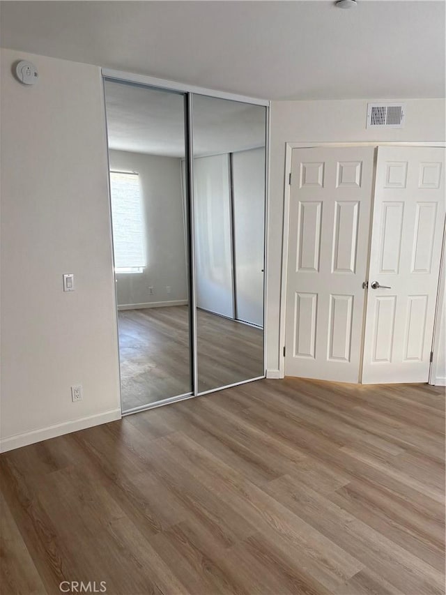 unfurnished bedroom with wood-type flooring