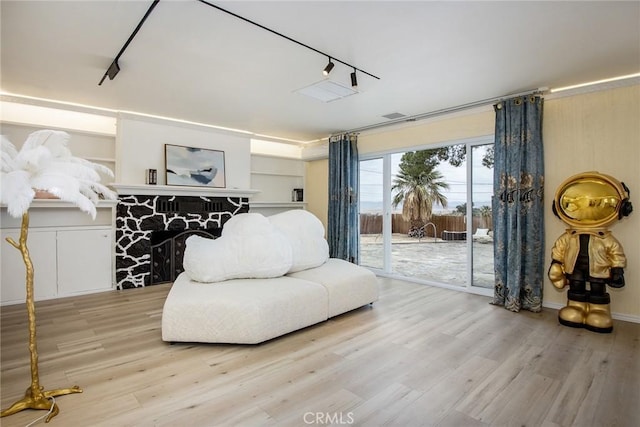 living area with hardwood / wood-style floors and rail lighting