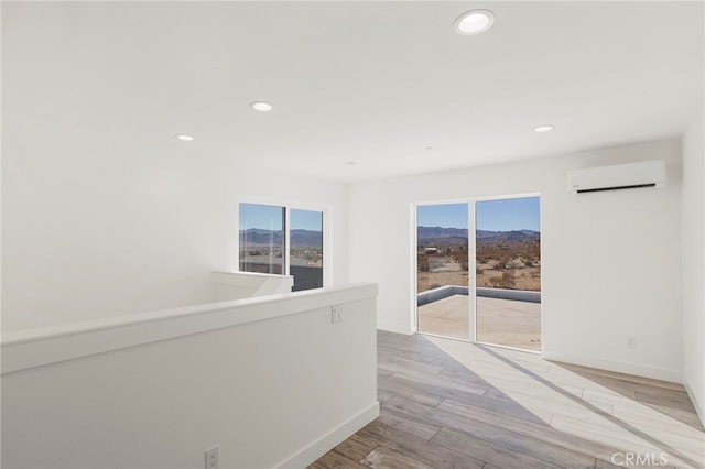 corridor featuring a wall mounted air conditioner and light hardwood / wood-style flooring