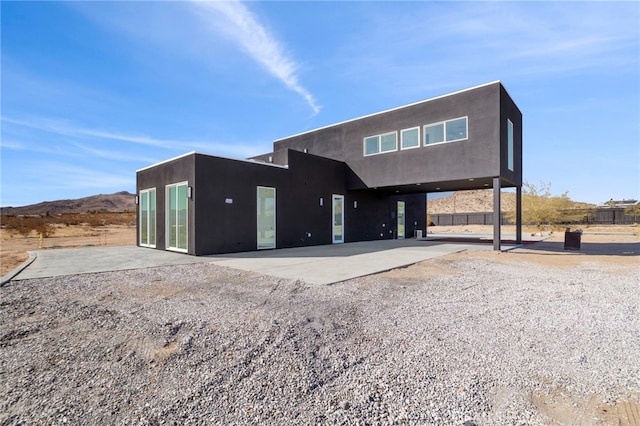 view of front of property with a mountain view and a patio area