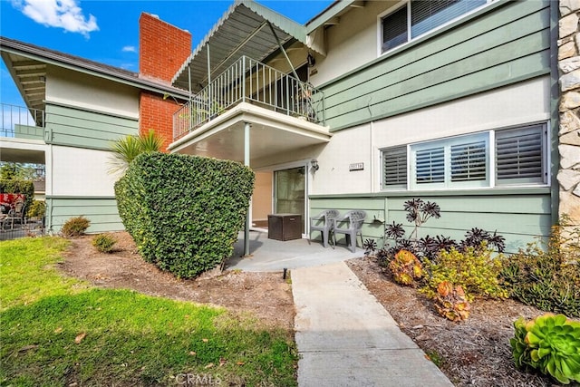 property entrance featuring a patio area and a balcony