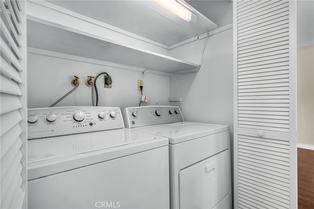 washroom with washer and clothes dryer and hardwood / wood-style floors