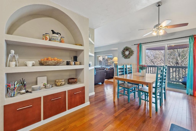 dining space with built in shelves, ceiling fan, and hardwood / wood-style flooring