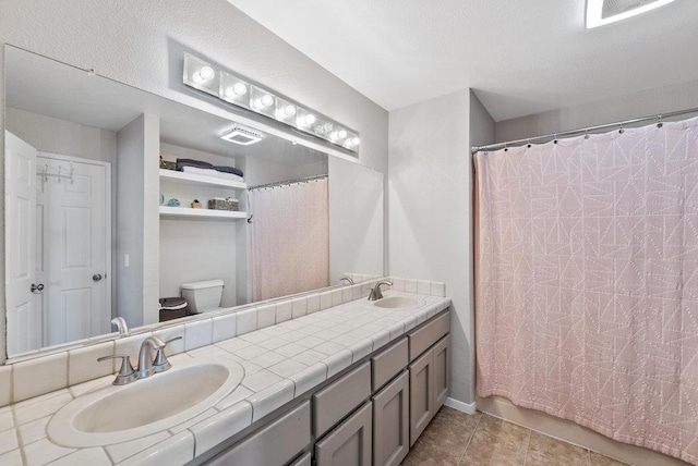 bathroom featuring walk in shower, tile patterned floors, vanity, and toilet