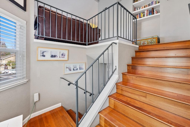 stairway featuring a high ceiling and hardwood / wood-style floors