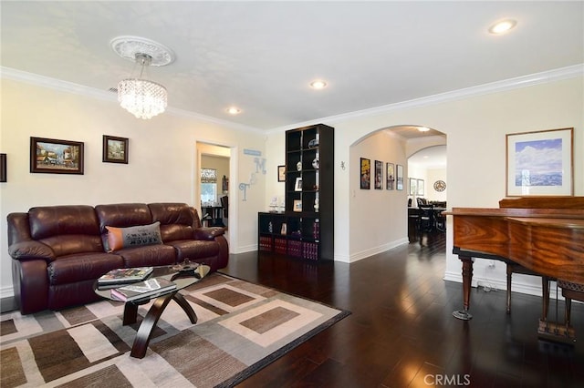 living room featuring dark wood-type flooring, crown molding, and a notable chandelier