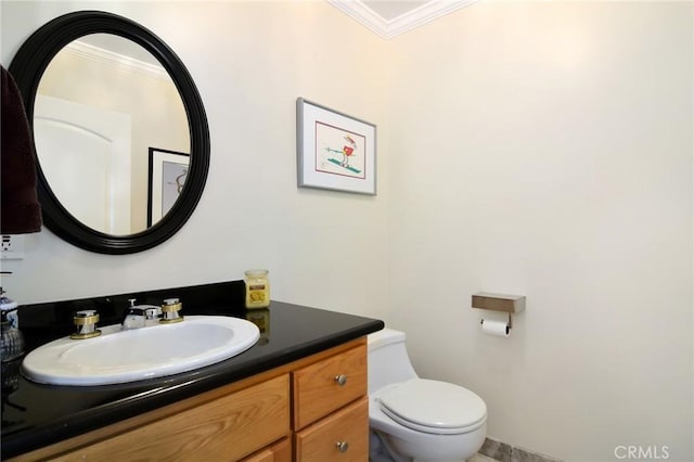 bathroom with toilet, crown molding, and vanity