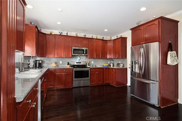 kitchen featuring stainless steel appliances, decorative backsplash, dark hardwood / wood-style flooring, ornamental molding, and light stone counters