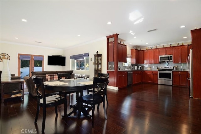 dining area with french doors, dark hardwood / wood-style floors, a wealth of natural light, and crown molding