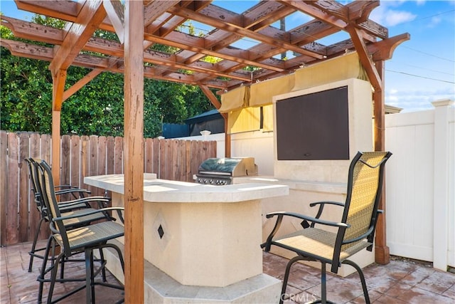 view of patio / terrace with a bar, a pergola, a grill, and area for grilling