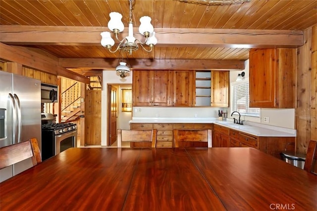 kitchen featuring decorative light fixtures, sink, beamed ceiling, stainless steel appliances, and a chandelier