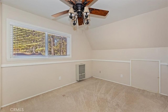 additional living space with vaulted ceiling, ceiling fan, heating unit, and light carpet