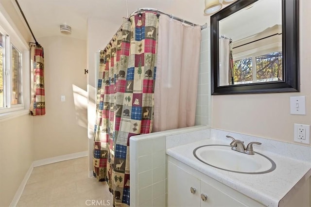 bathroom featuring tile patterned flooring, vanity, and curtained shower