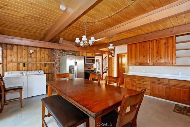 dining space featuring wood walls, wooden ceiling, washer and dryer, a chandelier, and beam ceiling