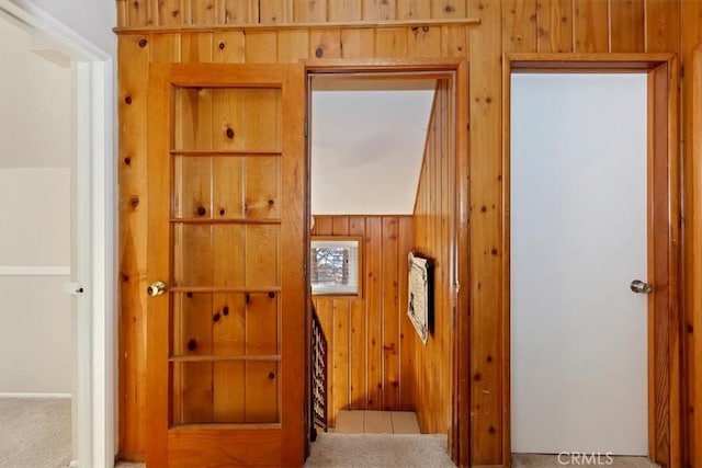 interior space with carpet and wooden walls