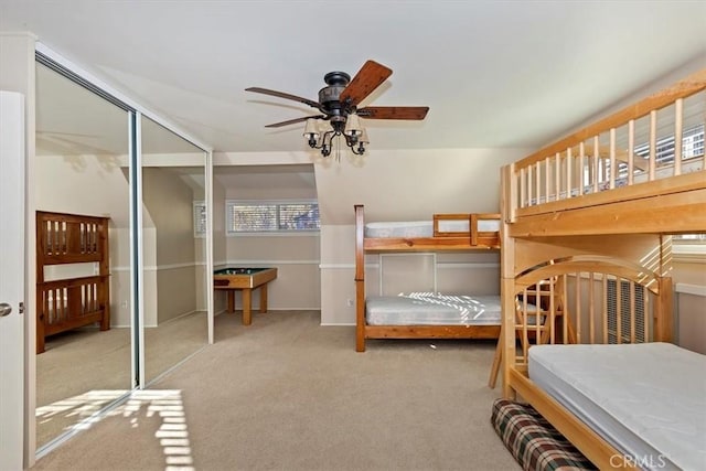 carpeted bedroom featuring a closet, multiple windows, and ceiling fan