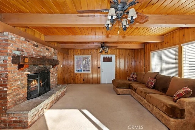 carpeted living room with a fireplace, wood walls, and beamed ceiling