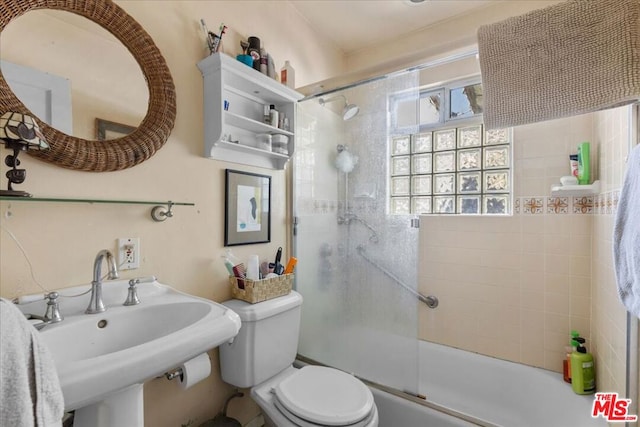 full bathroom featuring enclosed tub / shower combo, sink, and toilet