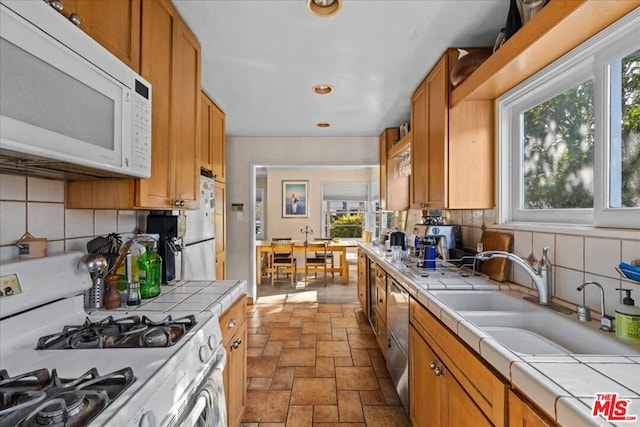 kitchen featuring backsplash, gas range, and tile counters