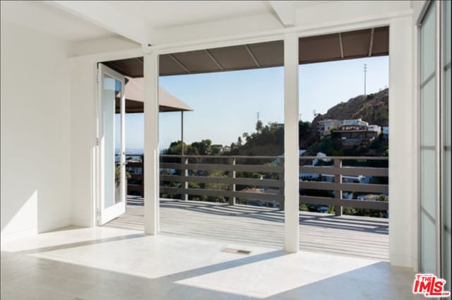 doorway to outside with beamed ceiling