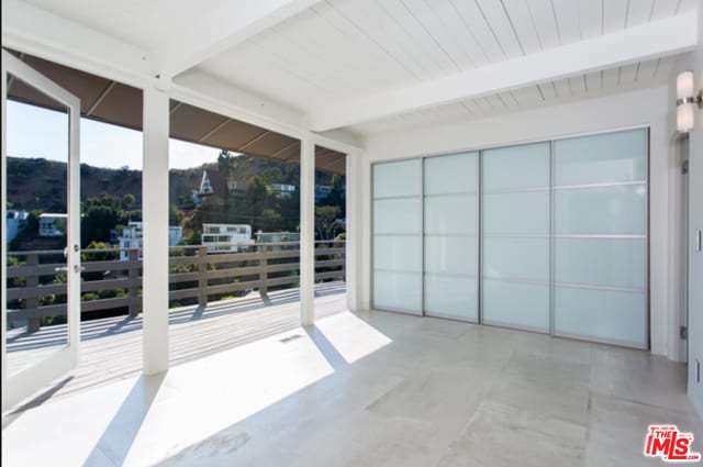 unfurnished sunroom featuring beam ceiling