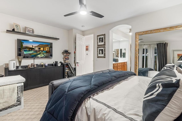 carpeted bedroom with connected bathroom and ceiling fan