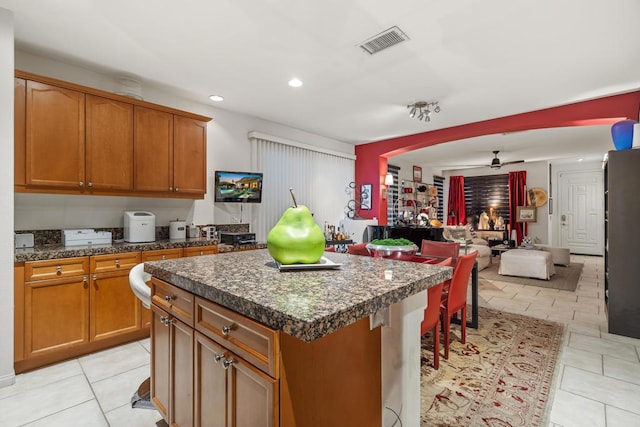 kitchen featuring ceiling fan, a center island, and light tile patterned flooring